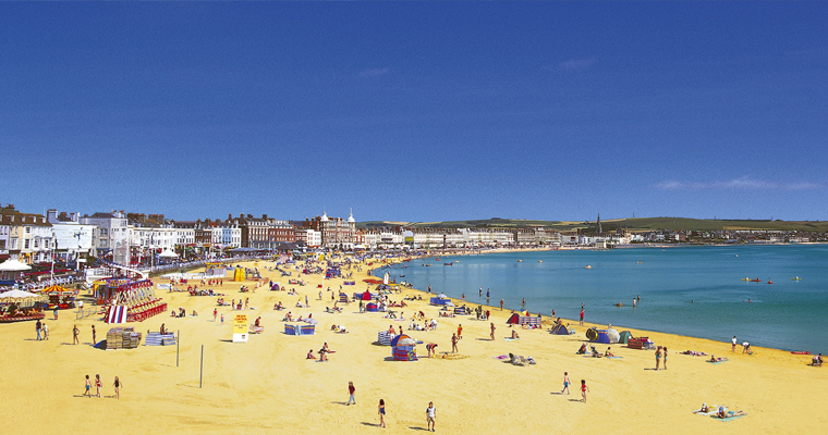 people enjoying a sunny day in Weymouth beach | SWR