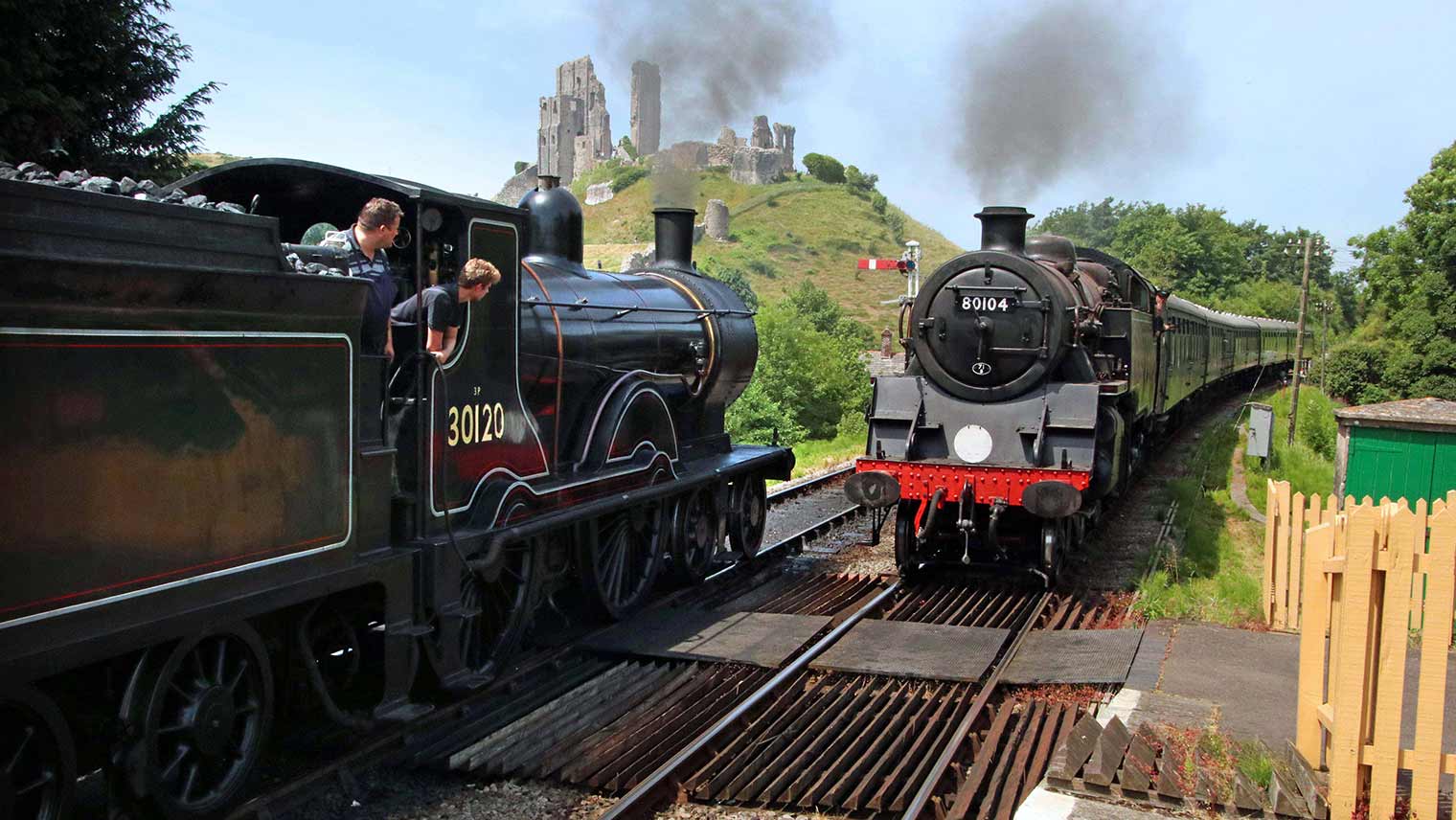 Swanage Railway steam trains passing each other below the ruins of Corfe Castle