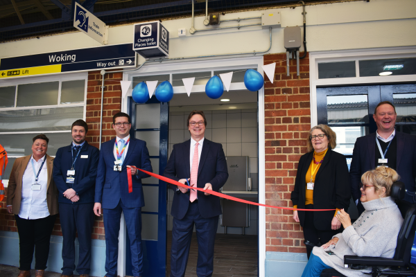 Group of people at ribbon cutting ceremony outside Changing Places toilet at Woking station