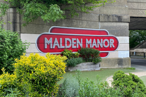 Mural of Malden manor station sign surrounded by greenery