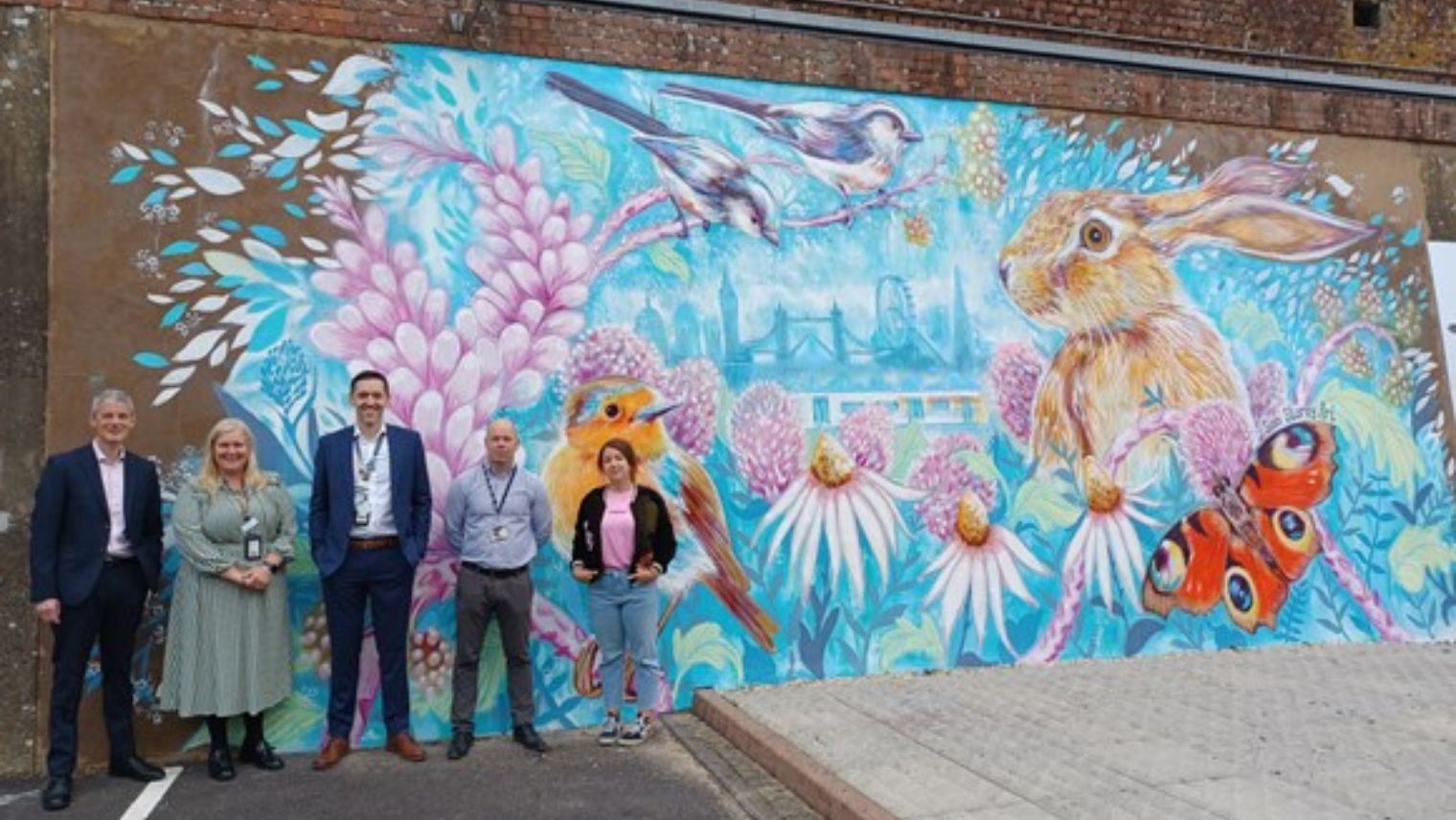 Sian Storey and south Western Railway employees by the new mural at Basingstoke station