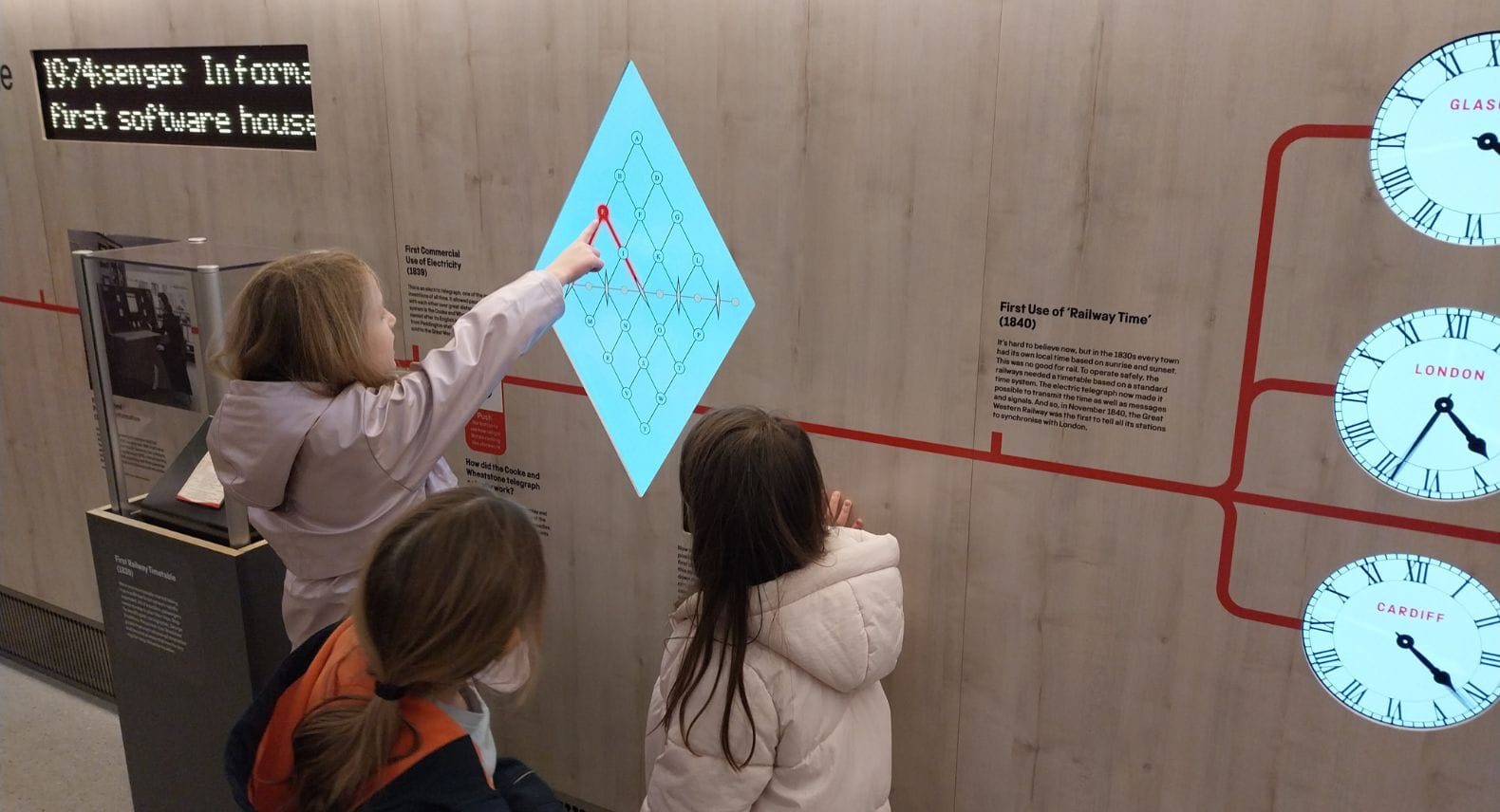 Children looking at a digital display inside a train carriage