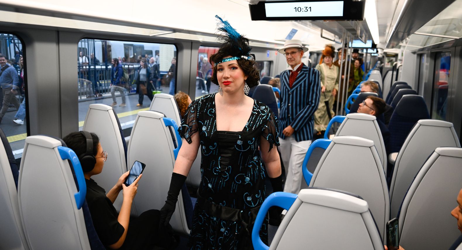 Woman in 1920's dress walking down the aisle of a train