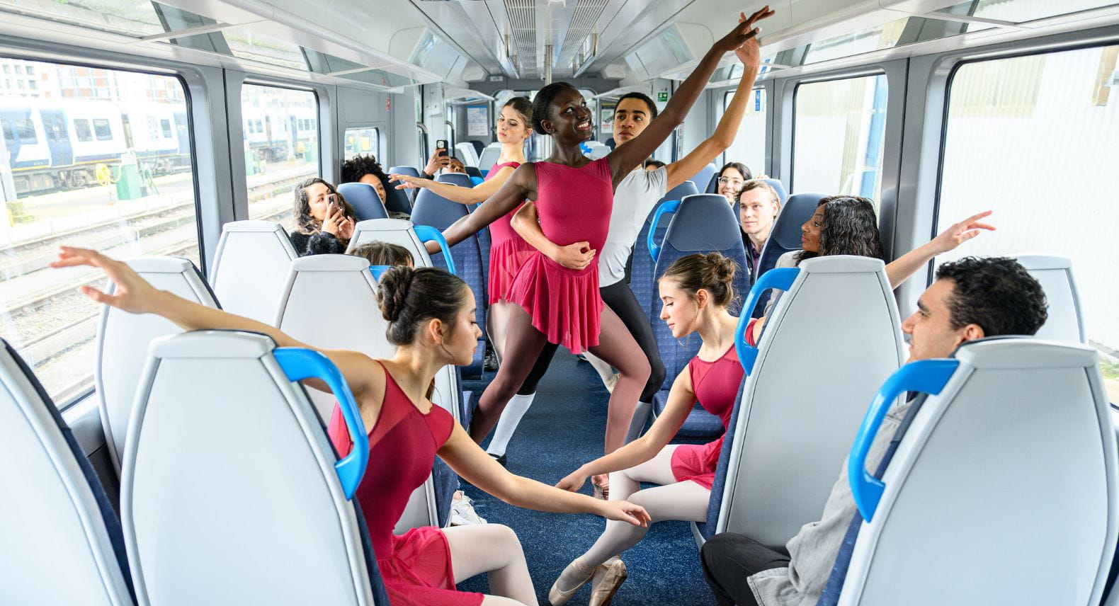 Group of young ballet dancers performing in front of customers on an Arterio train