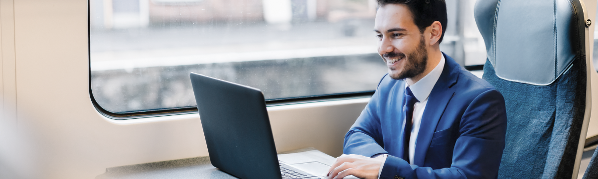 man sit in the train with a laptop