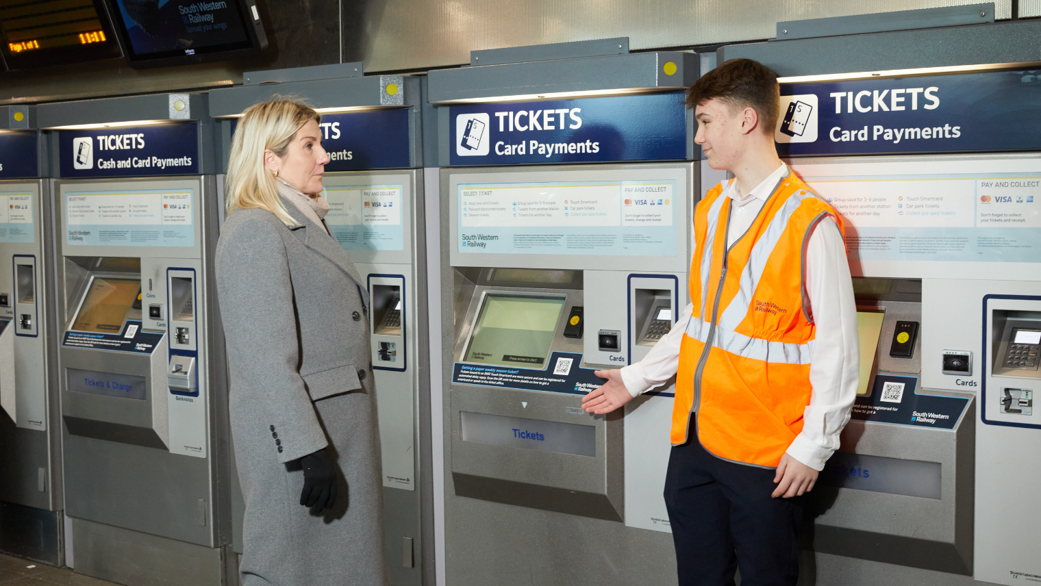 two people in front of a TVM machine