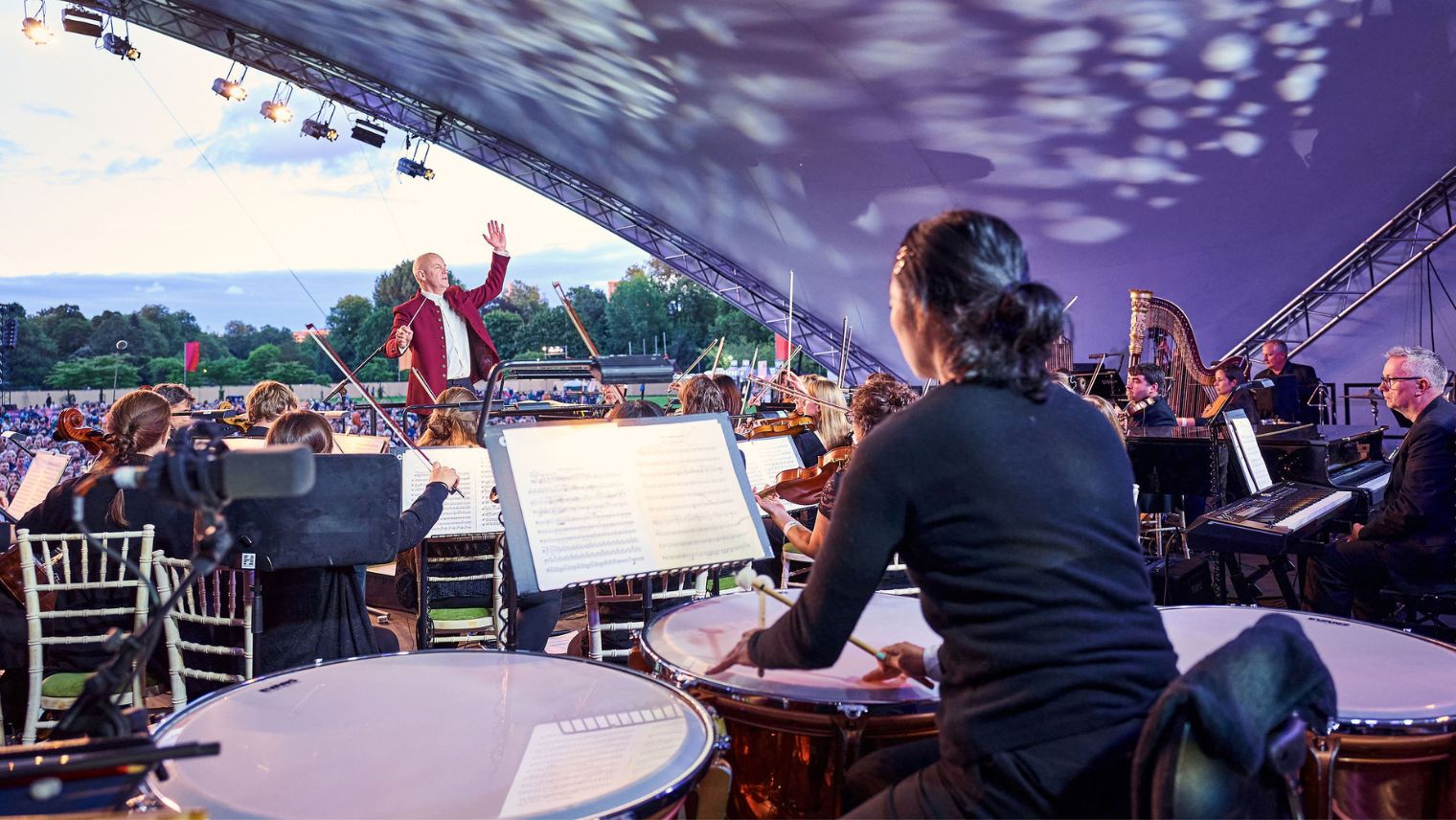 Close up of an orchestra on stage with conductor