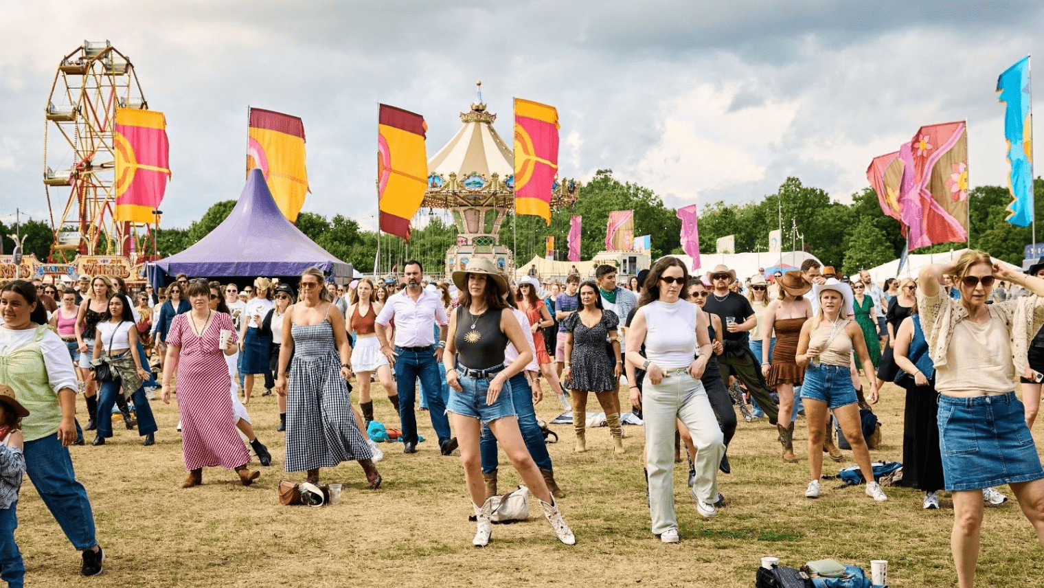  People dancing in an open field at a festival 