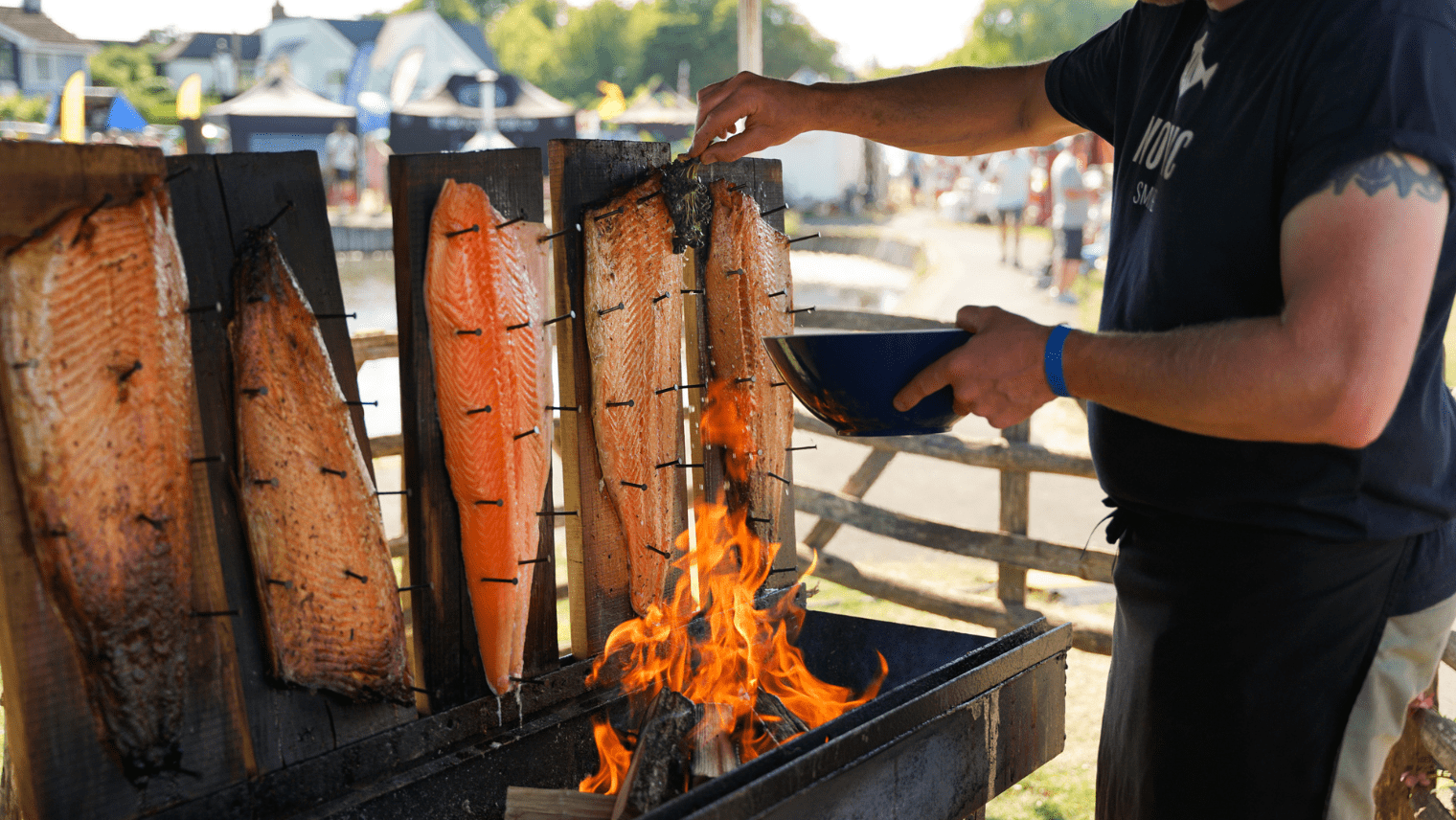Salmon fillets cooking over open fire at seafood festival 