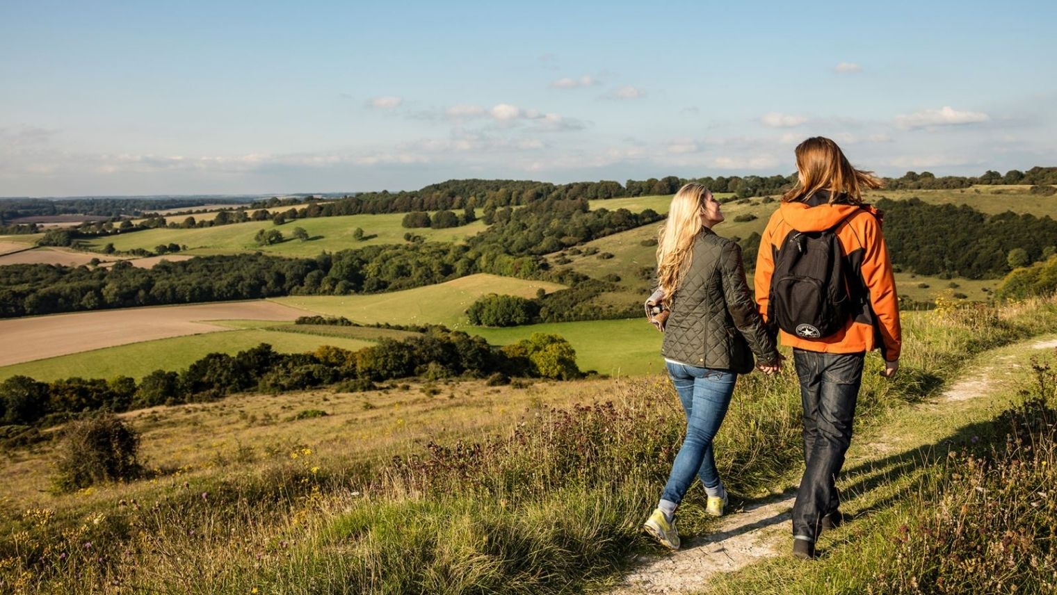 Two women walking together in the South Downs in Winchester