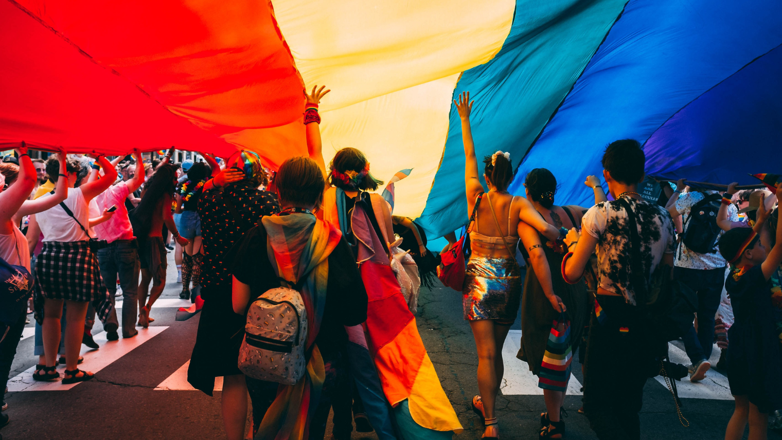 A crowd of people marching the streets at a Pride event
