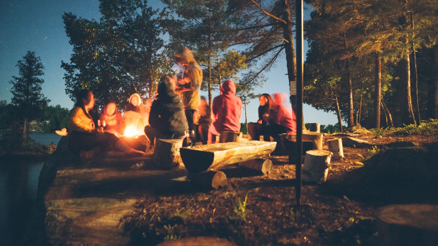Image of a group of people sat around a campfire 