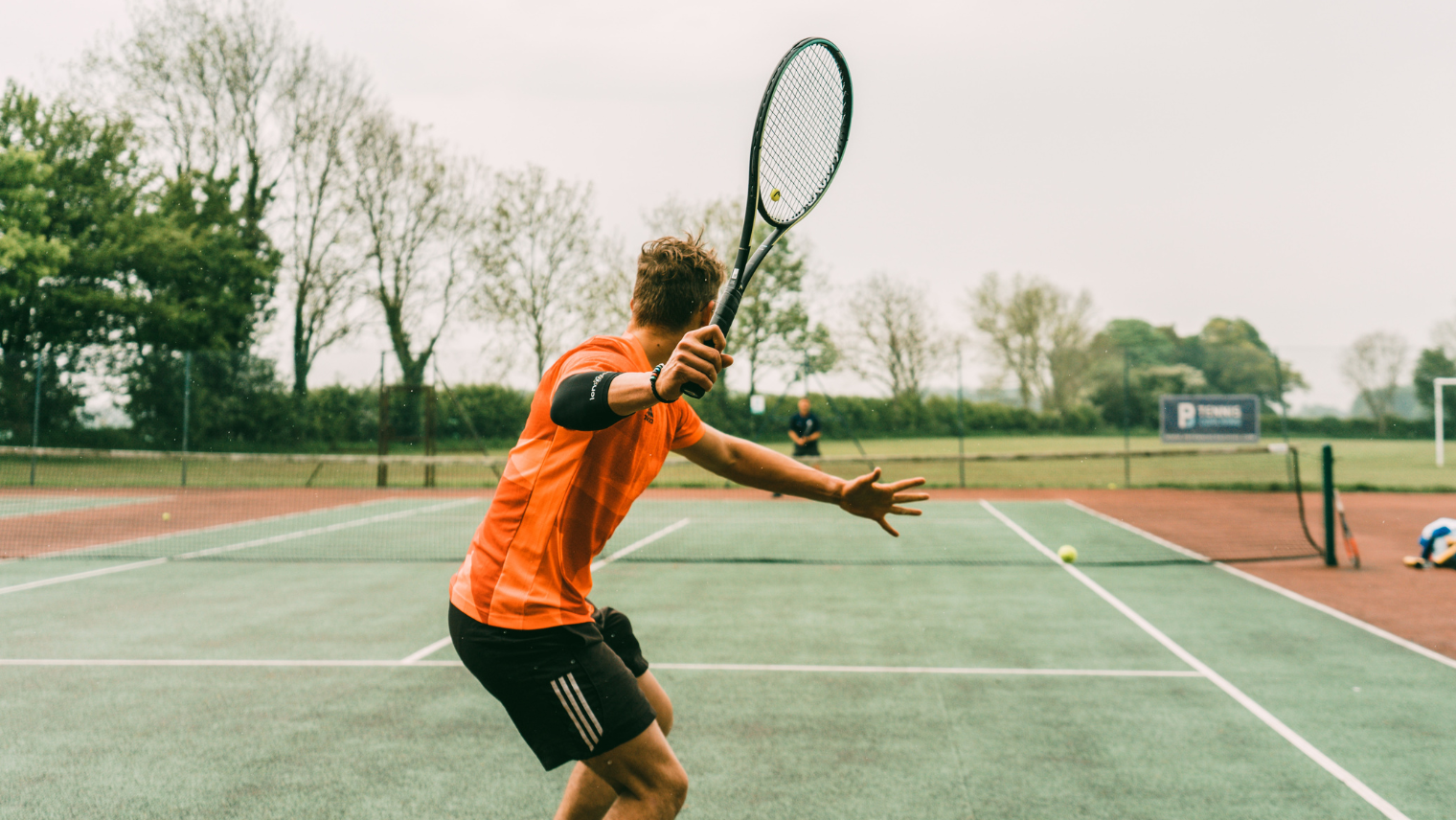 An image of 2 people playing tennis on a court