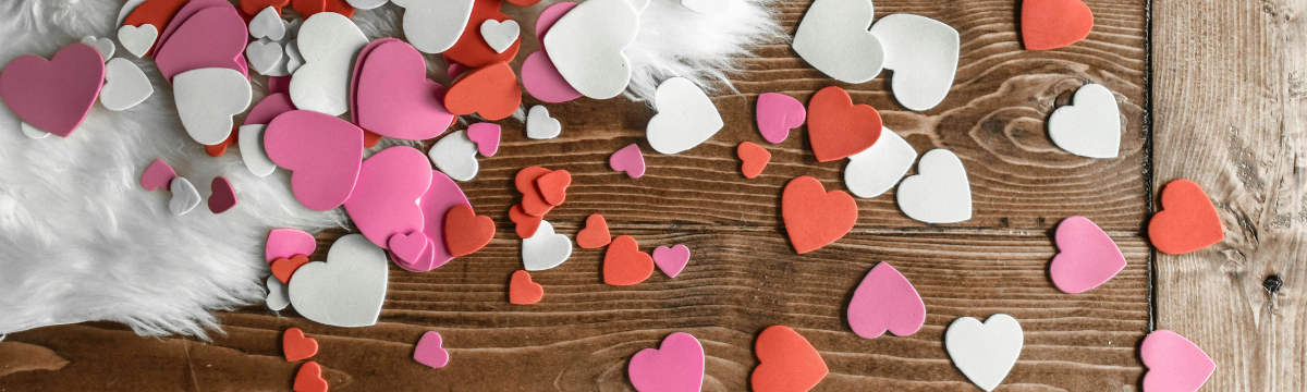 Different colour love hearts on a wooden table