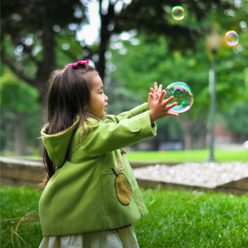 girl play with soap ball in the park
