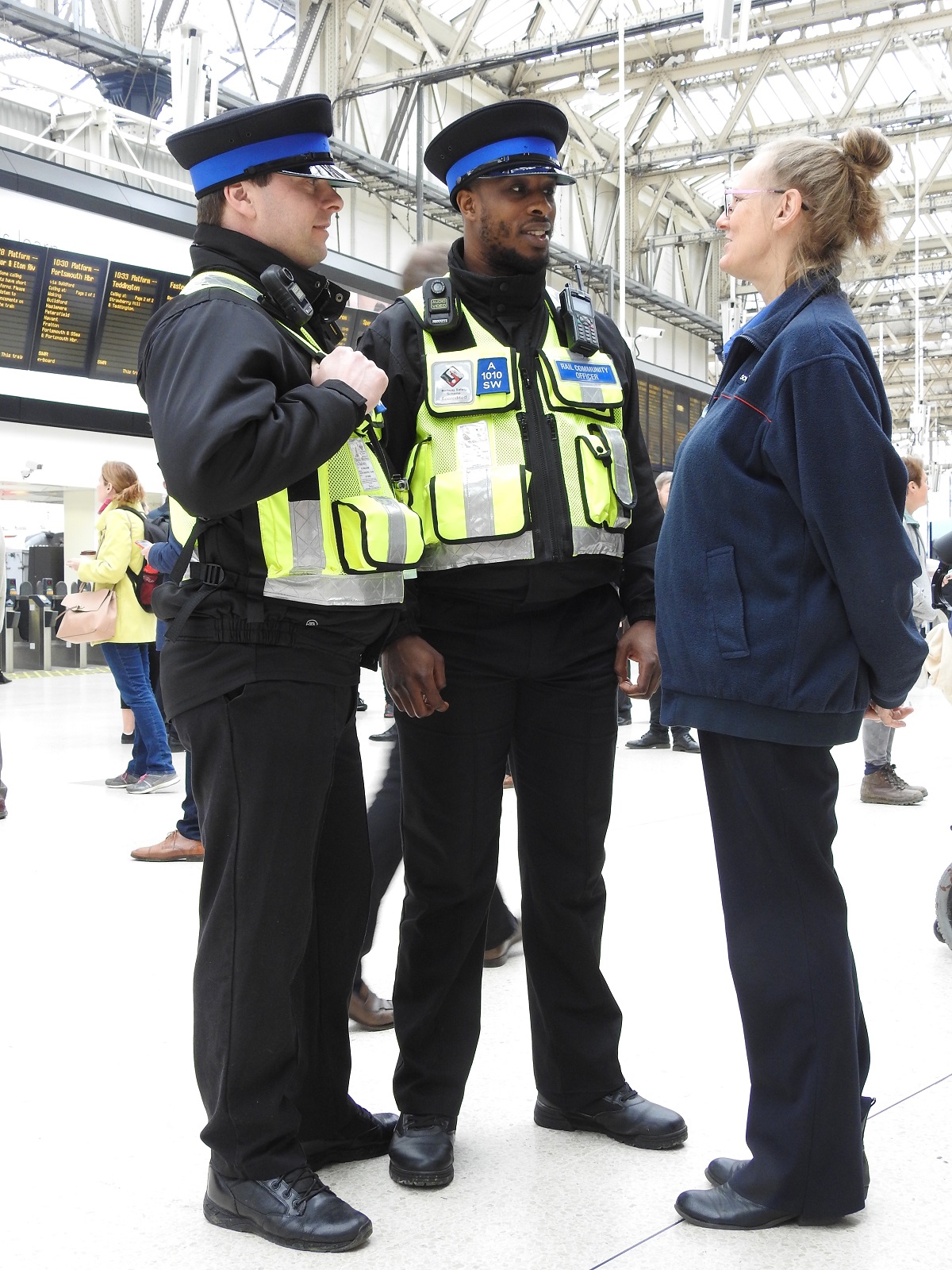 Two Rail Community Officers stand talking to a member of the station team at London Waterloo