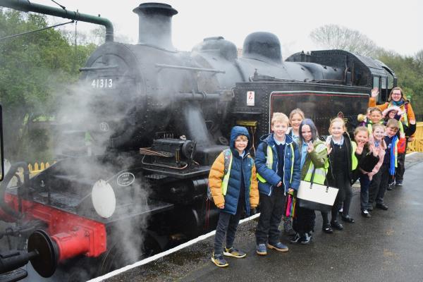 Group of children in front of steam engine on Isle of Wight
