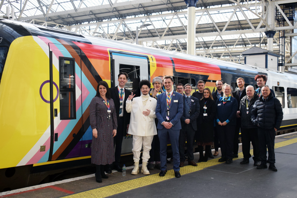SWR Class 444 train at Waterloo with Intersex Inclusive livery. Assorted group of people standing beside the train