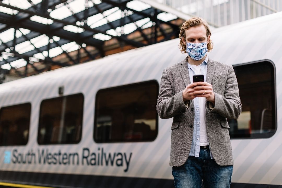 Businessman using phone at train station
