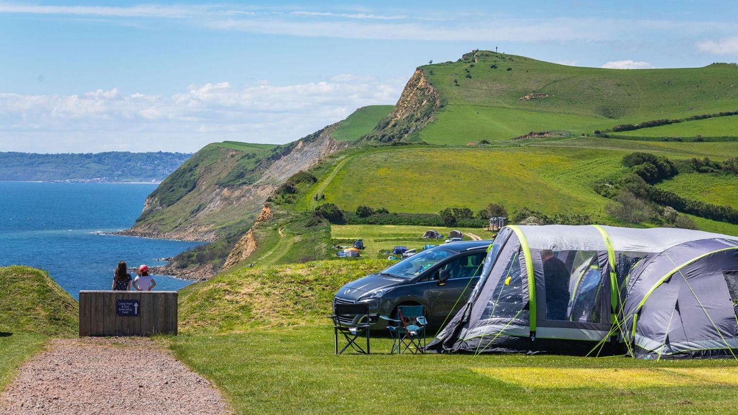 A view over the Jurassic coastline with a tent at Rosewall campsite in the foreground