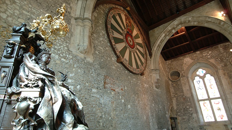 Body Image - a statue of Queen Victoria at the Great Hall, Winchester. The 'round table' from King Arthur's mythology hangs on the wall in the background.