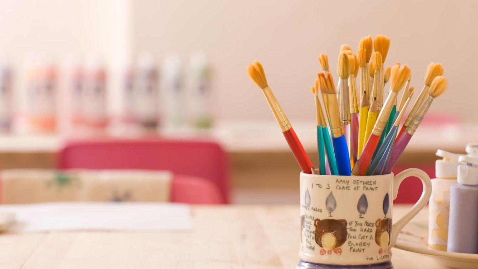 A hand-painted cup holding paintbrushes at Pottery Café, Clapham