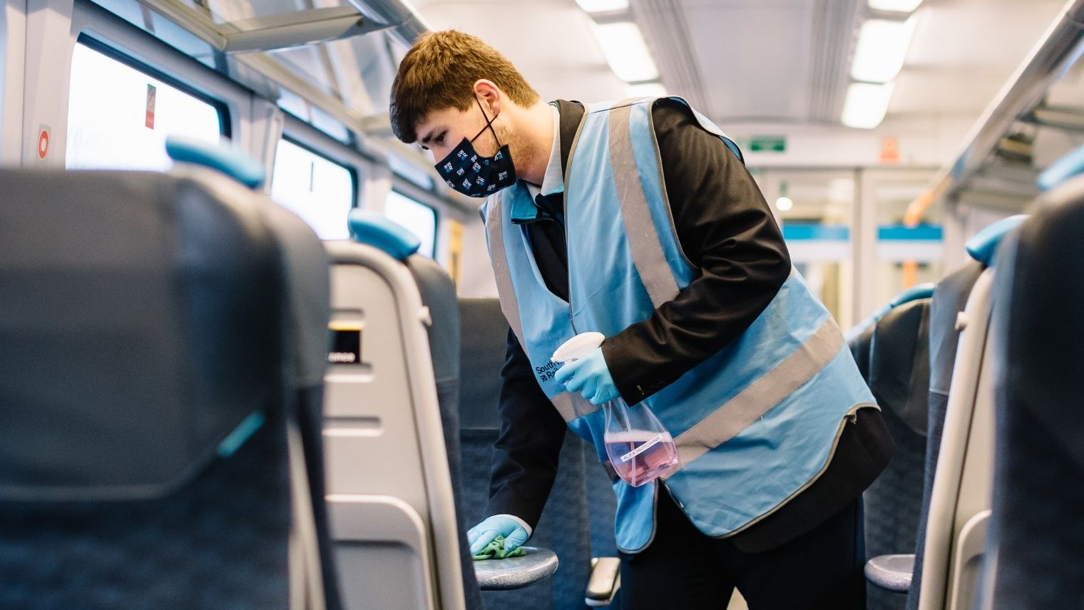Staff member cleaning a table on board a train