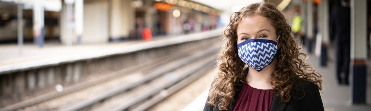 Wheelchair user wearing mask on train station platform